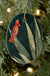 The Arizona Cardinal oval ceramic ornament against a Christmas tree background.