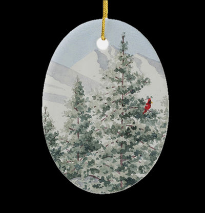 Close up of Pure White oval ceramic ornament. It features a snowy landscape with a red cardinal perched in a tree.