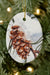 The Snow Cone oval ceramic ornament against a Christmas tree background.