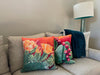 Two throw pillows on a couch, the "Abundance" and "Juicy Fruit" pillows.