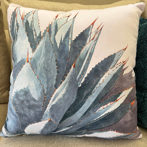 The Clarity throw pillow. It features the watercolor painting of a blue agave printed on a throw pillow.