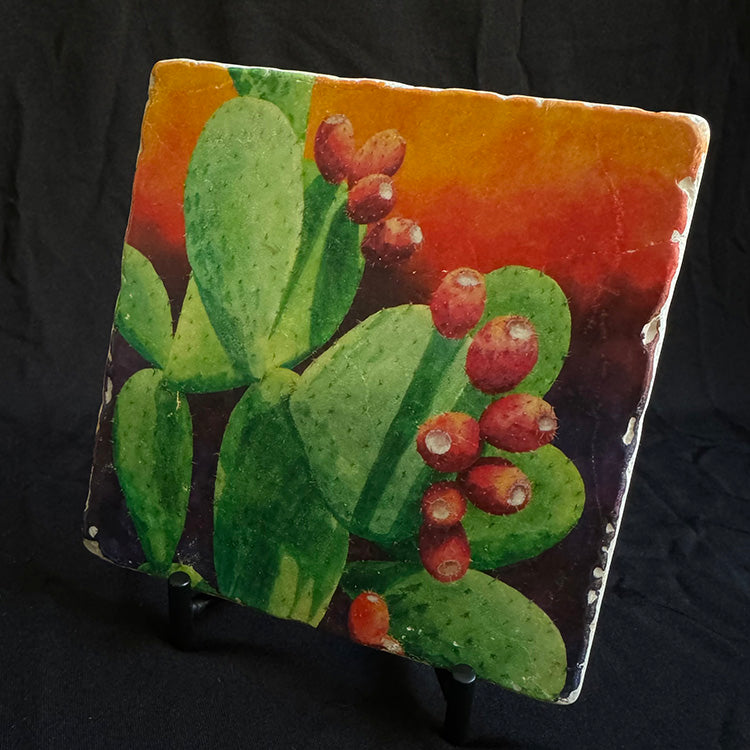The "Juicy Fruit" trivet featured on its iron stand. The image is a watercolor painting of a fruiting prickly pear.