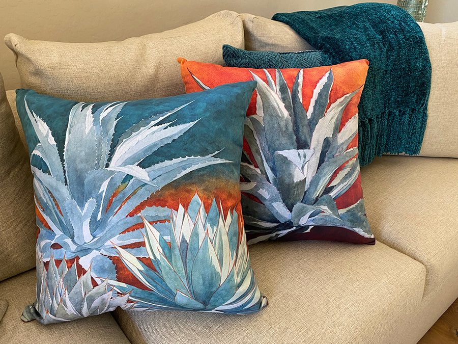 The All in the Family and Tequila Sunrise decorative pillows on a couch