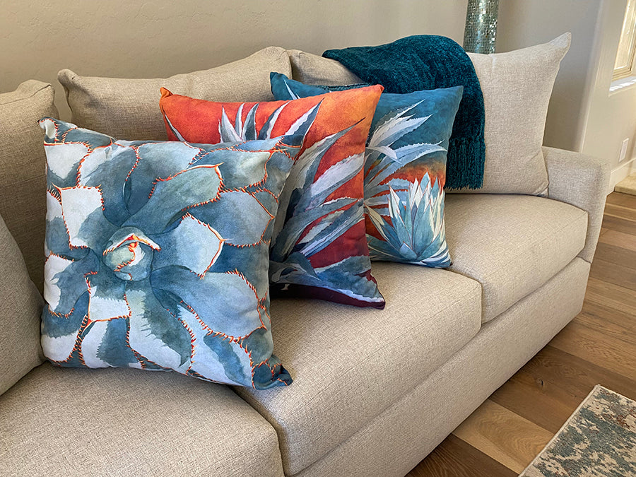 The Stick With Me, Tequila Sunrise, and All In The Family decorative pillow on a couch as a decorative example