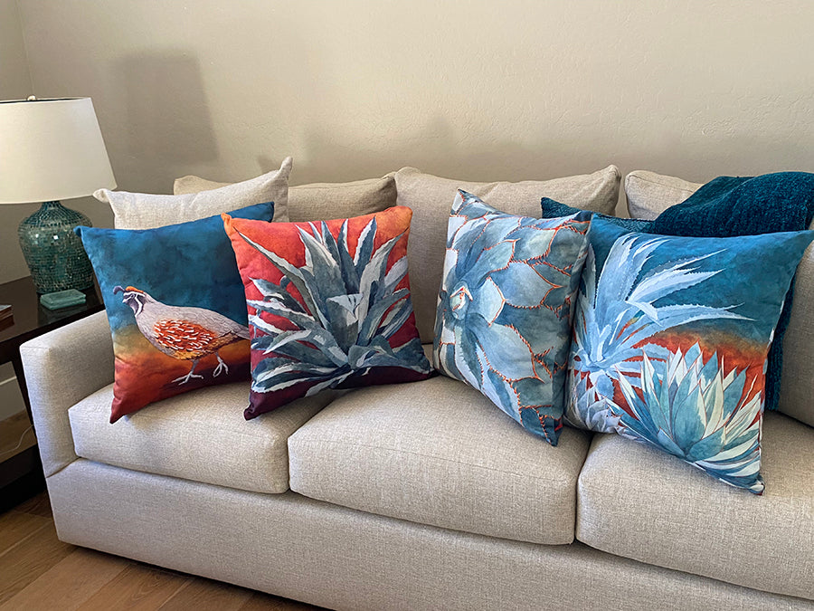 The Follow the Leader, Tequila Sunrise, Stick With Me, and All in the Family pillows on display on a couch