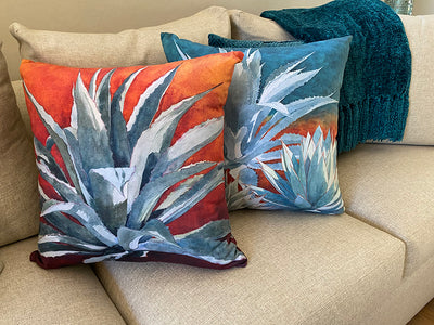 The Tequila Sunrise and All In The Family decorative pillows on a couch