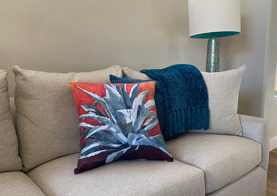 Wideshot of Tequila Sunrise decorative pillow on a couch